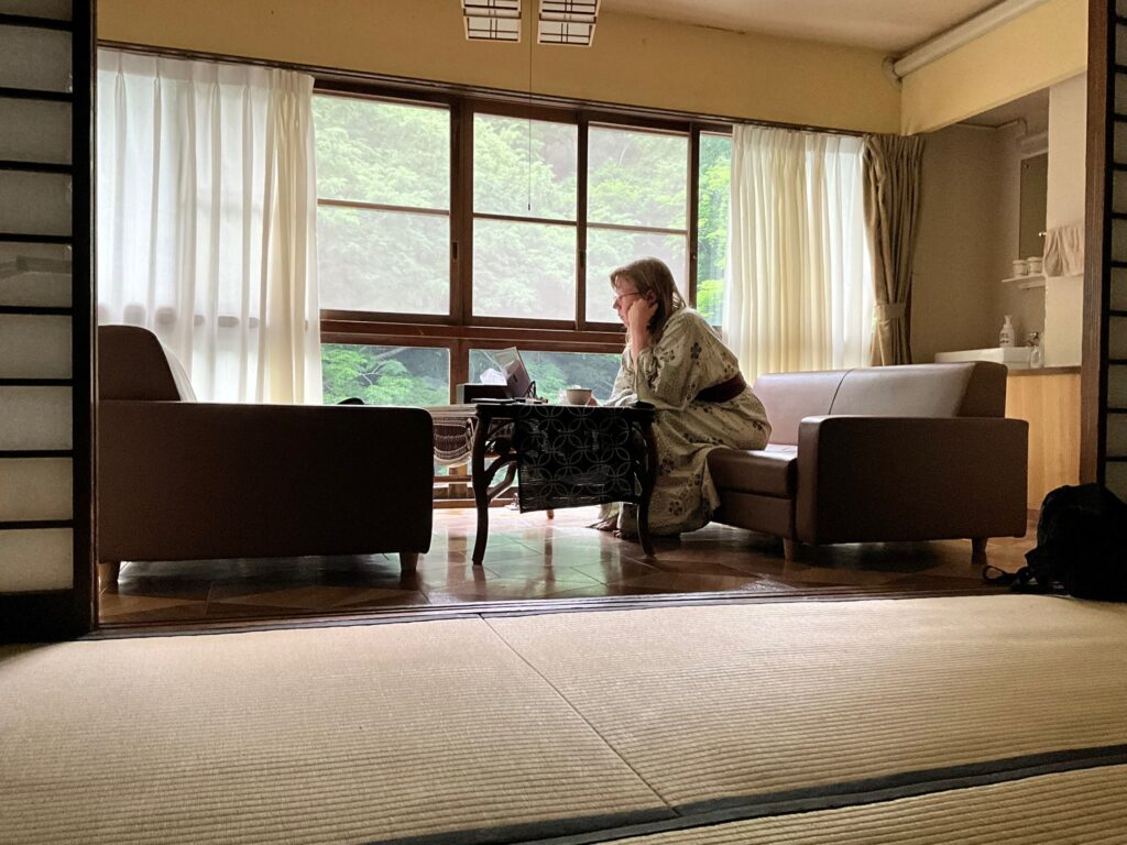 Chrissy working at her computer in their ryokan room.
